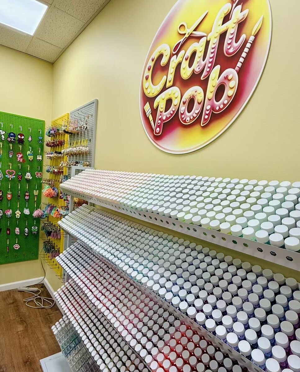Wall of craft supply jars under the Craft Pop sign at the Astoria studio