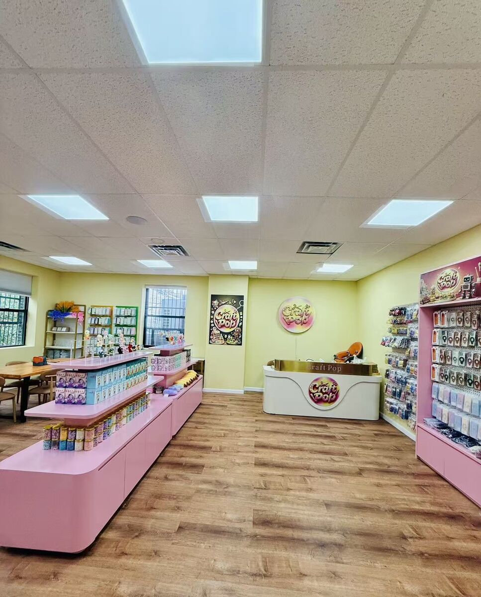 Inside the Craft Pop kids craft studio in Astoria with pink supply counters, yellow walls and the Craft Pop front desk