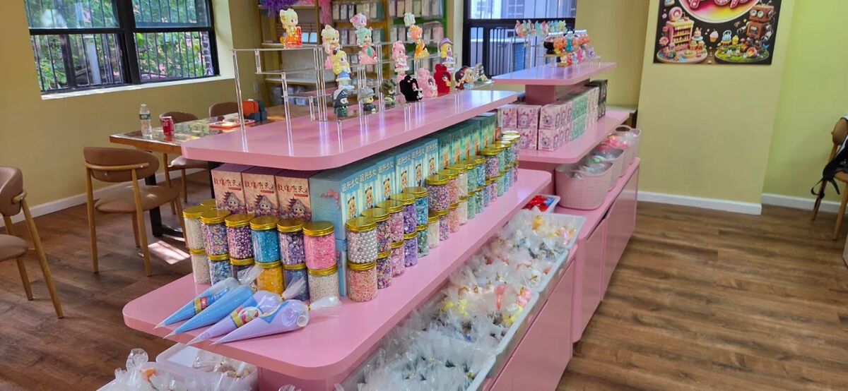 Long pink counters stocked with jars of craft supplies inside Craft Pop