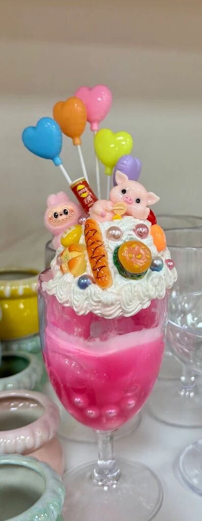 Tall pink dessert glass with cream glue and balloon toppers