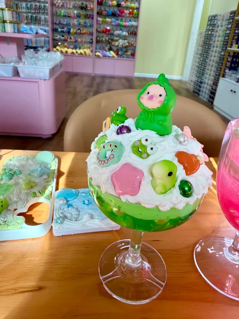 Green cream glue sundae cup with frog and flower charms made by a child at Craft Pop