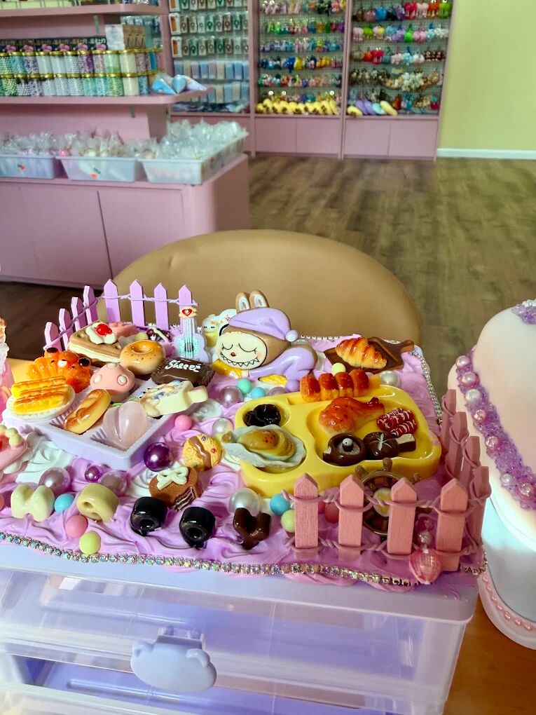Cream glue tray decorated with miniature food charms and a picket fence on a craft table at Craft Pop