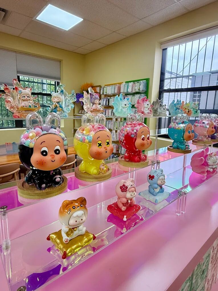 Big-headed painted figurines displayed on a pink acrylic shelf